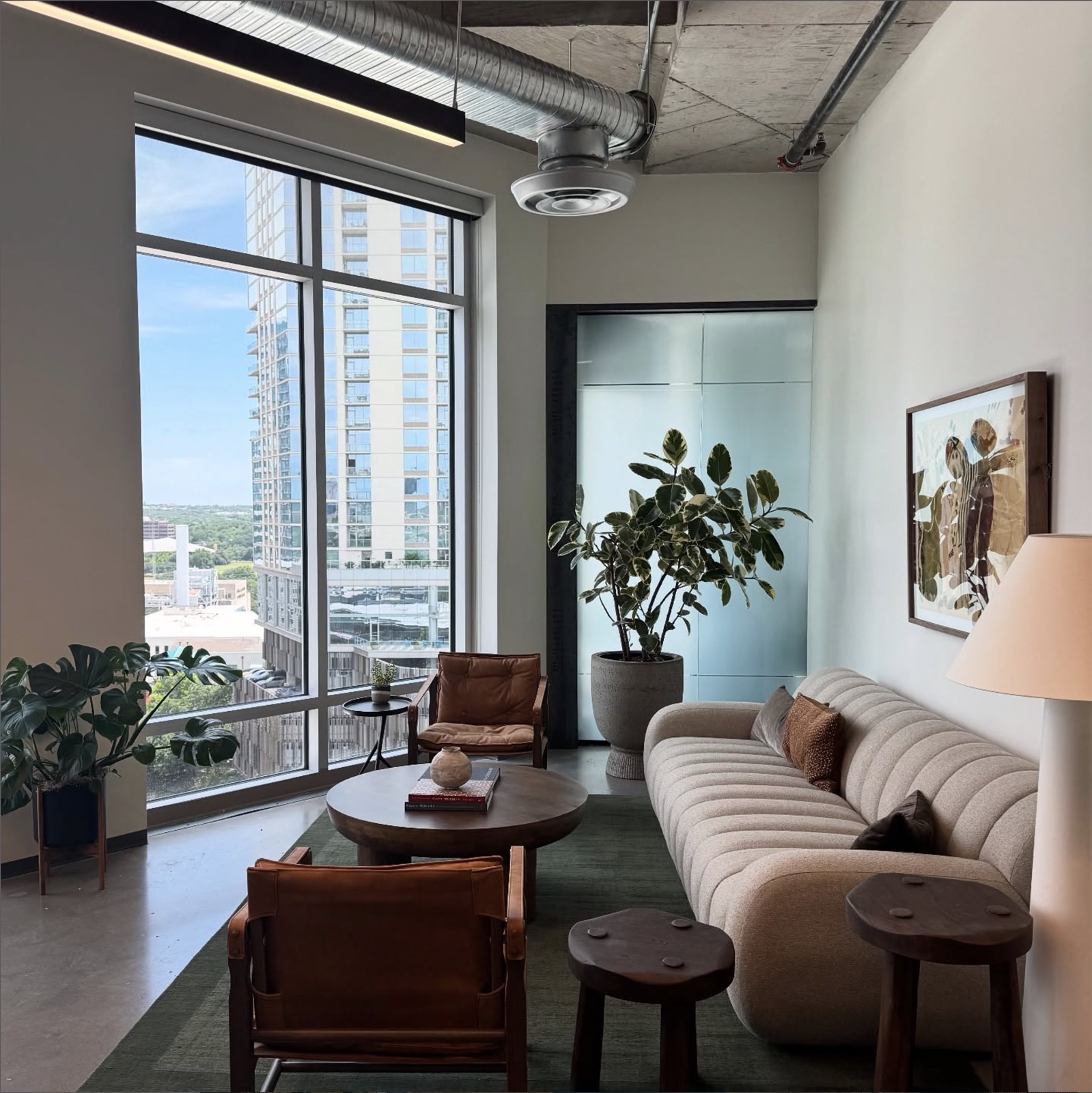 A curated downtown Austin office lounge with monstera and rubber plant
